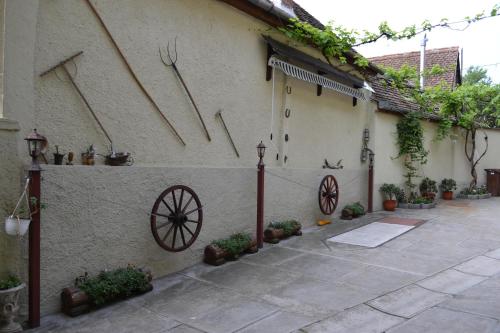 a courtyard of a house with a wall with a wheel on it at Pensiunea Muntean in Sibiel