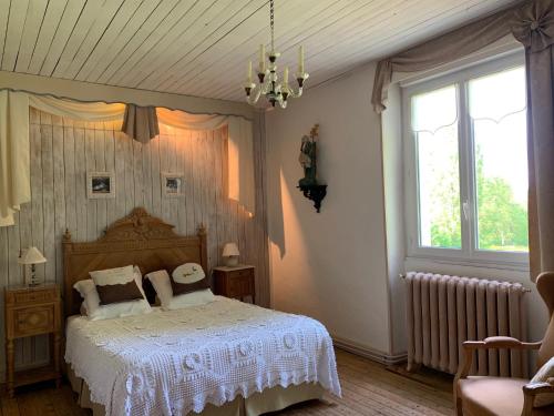 Schlafzimmer mit einem Bett mit weißer Bettwäsche und einem Fenster in der Unterkunft L'île Ô Reflets in Trôo