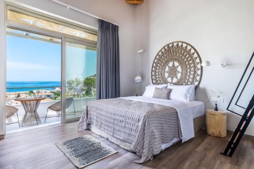 Un dormitorio con una cama grande y un balcón. en Villa Kingstone 2, en Skopelos Town