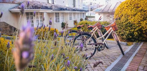 a bike parked in a garden next to a house at Pousada Nacional Inn Campos do Jordão in Campos do Jordão