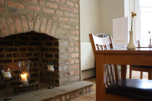 a brick fireplace with a candle and a desk at Nama-Stay Harrogate in Harrogate