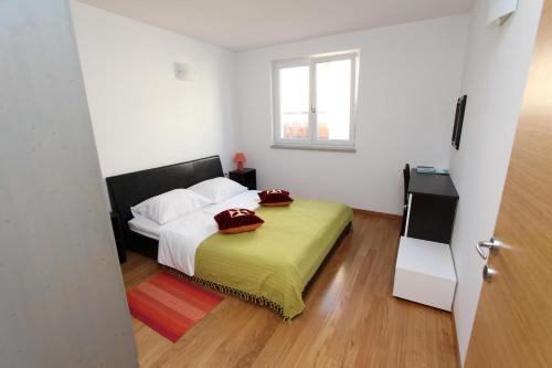 ein Schlafzimmer mit einem Bett mit roten Kissen darauf in der Unterkunft Apartments Hanna in Rovinj