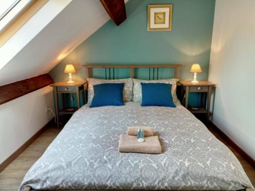 a bedroom with a large bed with blue pillows at Libellule in Coussac-Bonneval