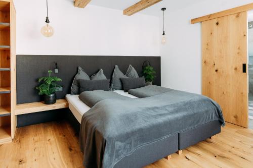 a bedroom with a large bed with a gray blanket at Voglstätter Appartements Lofer in Lofer