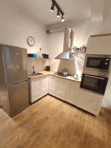 una cocina con armarios blancos y electrodomésticos de acero inoxidable en Precioso y acogedor piso en la Seu de Urgell, en La Seu d'Urgell
