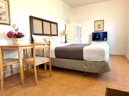 a bedroom with a bed and a desk with a computer on it at Motel Saint-Hilaire in Mont-Saint-Hilaire