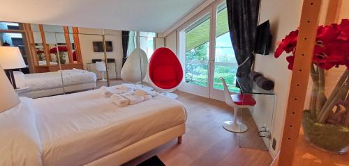 a bedroom with a white bed and a red chair at Villa Le France - Vision Luxe in Veyrier-du-Lac
