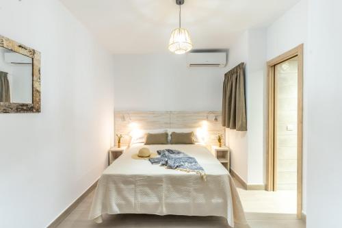 a white bedroom with a bed and a mirror at Hostal Rosell Boutique in San Antonio