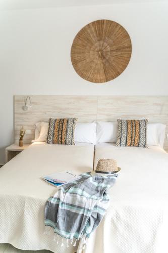 a bedroom with a bed with a hat on it at Hostal Rosell Boutique in San Antonio