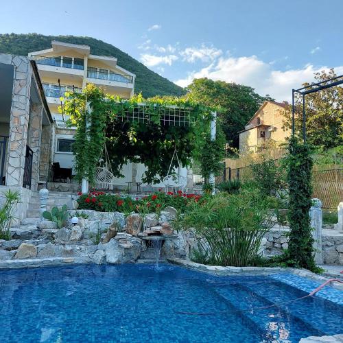 a swimming pool in a yard with a house at Apartmani VERONA in Bijela
