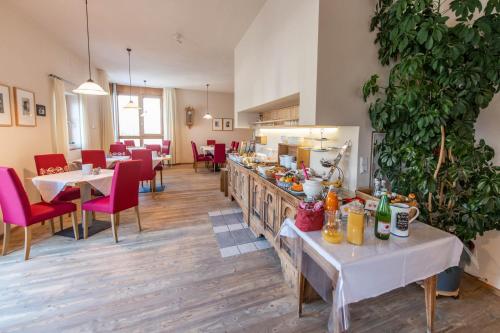 een restaurant met tafels en stoelen en een bar met eten bij Hotel Garni Zum Hirschen in Malles Venosta