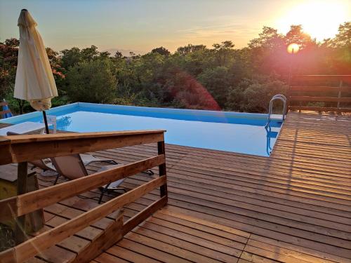 uma piscina num deque com um guarda-sol em Le Mimose B&B em Vinci