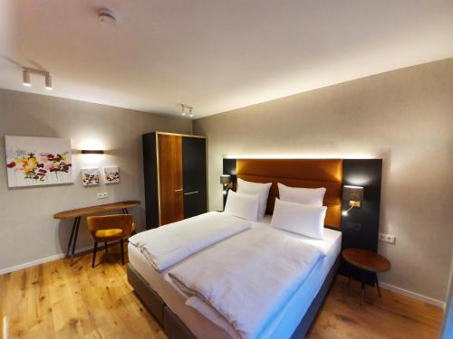 ein Schlafzimmer mit einem großen Bett und einem Schreibtisch in der Unterkunft Erasmus Lodge - Ferienwohnungen zum Wohlfühlen in Trassem
