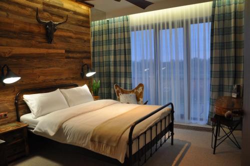 a bedroom with a bed and a large window at The Country Club in Toruń
