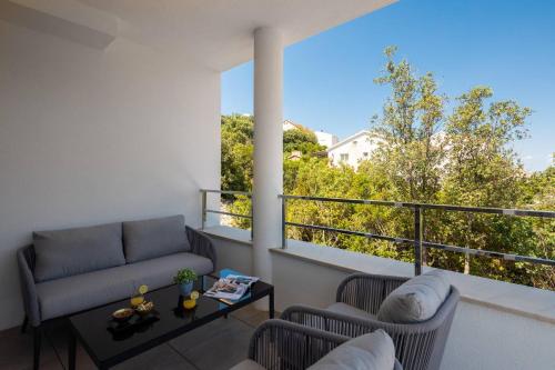 a living room with a couch and a table on a balcony at Villa Buddha Bay in Korčula