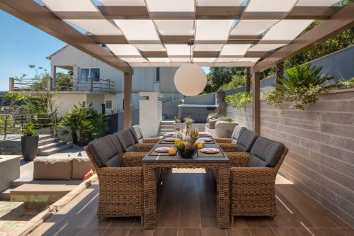an outdoor dining room with a table and chairs on a patio at Villa Buddha Bay in Korčula