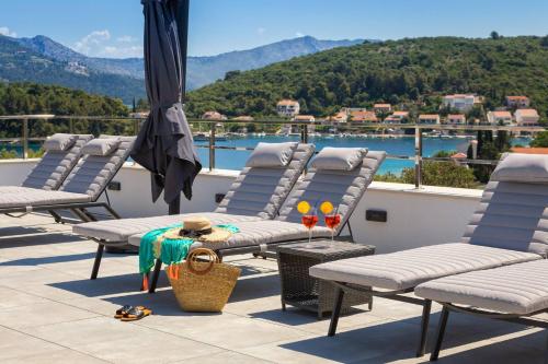 a group of chairs and an umbrella on a balcony at Villa Buddha Bay in Korčula