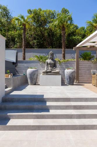 a statue of a woman sitting on a pedestal in a courtyard at Villa Buddha Bay in Korčula