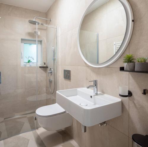 a bathroom with a sink and a toilet and a mirror at Villa Buddha Bay in Korčula