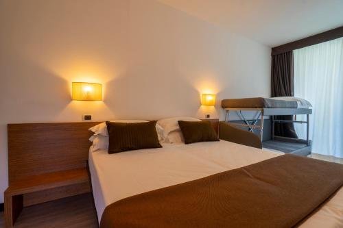 a bedroom with a bed and two lights on the wall at Hotel Cristallo in Rimini