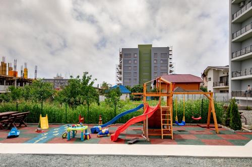 um parque infantil com um escorrega e uma estrutura de jogos em Vila Kos em Mamaia Nord – Năvodari