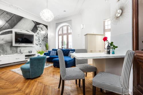 a living room with blue chairs and a table at Apartamenty4you - Apartamenty Atlantic in Sopot