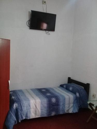 a bedroom with a bed and a flat screen tv on the wall at Brisas Del Rio Apart Hotel in Termas del Daymán