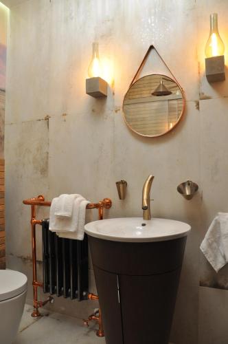 een badkamer met een wastafel en een spiegel aan de muur bij The Country Club in Toruń