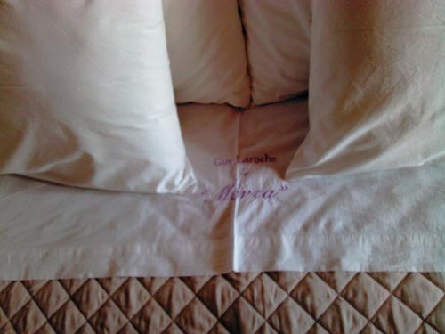a close up of a bed with white sheets and pillows at Menta( Archontiko Machalioti ) in Karpenision