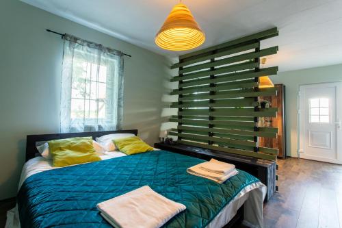 a bedroom with a bed with green sheets and yellow pillows at Seosko Domaćinstvo Pustolov in Stari Banovci