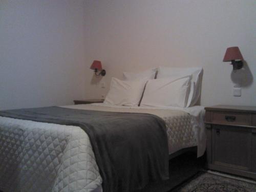 a bedroom with a bed with white sheets and pillows at Menta( Archontiko Machalioti ) in Karpenision