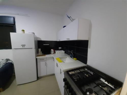 uma cozinha com armários brancos e um forno com placa de fogão em family2 em Nahariya