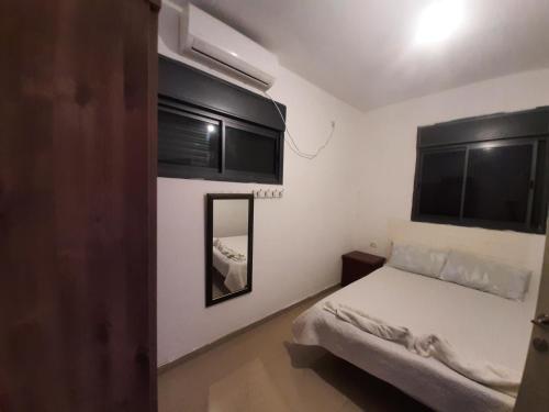 a small bedroom with a bed and black cabinets at family2 in Nahariyya