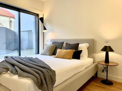 a bedroom with a bed and a large window at Oporto Chic&Cozy - Batalha II in Porto