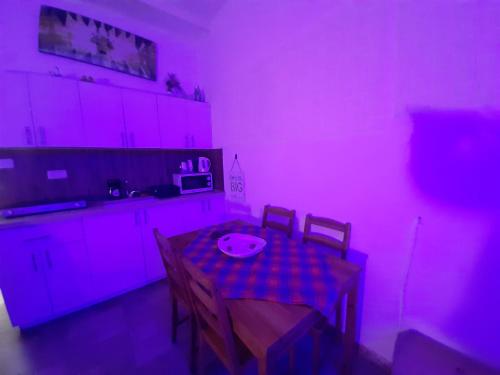 a kitchen with a table with a pink light on it at comft suite Nahariyya in Nahariyya