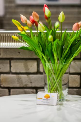a vase filled with flowers sitting on a table at Apartamenty4you - Apartamenty Atlantic in Sopot