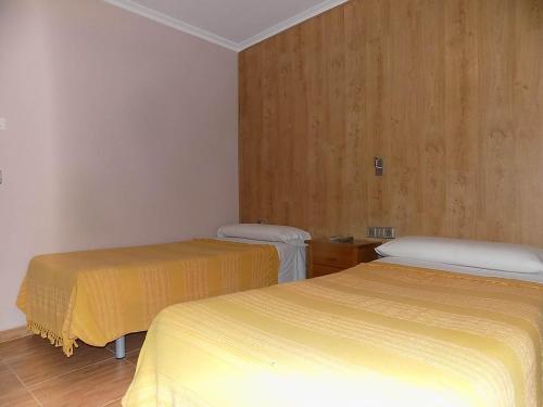 2 Betten in einem Zimmer mit gelber Bettwäsche in der Unterkunft Hostal Los Palancares in Fuentes