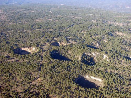 an aerial view of a forested area with many lakes at Hostal Los Palancares in Fuentes