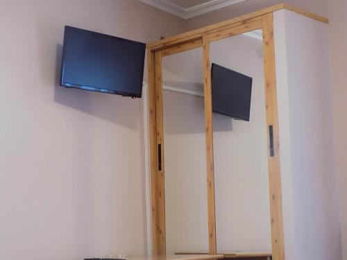 einen TV an der Wand in einem Zimmer in der Unterkunft Hostal Los Palancares in Fuentes