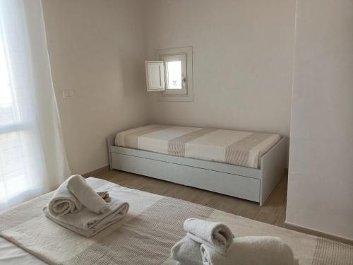 a bedroom with a bed with towels on the floor at casa venere 27 Favignana in Favignana