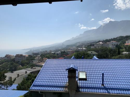 un toit bleu d'un bâtiment avec une montagne en arrière-plan dans l'établissement Mini - hotel Knyajiy Grad, à Haspra