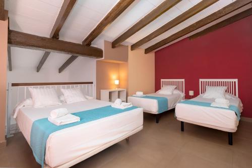 Dos camas en una habitación con paredes rojas. en Adarve Flats, en Valencia