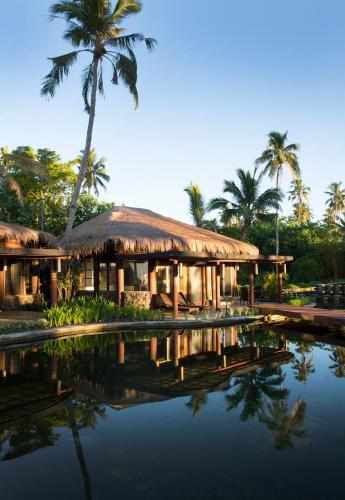 a resort with palm trees and a pool of water at Coconuts Beach Club Resort and Spa in Fausaga