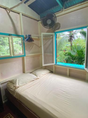 a small bed in a room with a window at Hidden Jungle Beach House in Puerto Viejo
