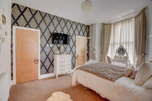 a bedroom with a white bed and a white dresser at Bunny Burrow in Whitby