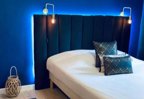 1 dormitorio con paredes azules y 1 cama con 2 almohadas en L'appart Botanic Metz, en Metz