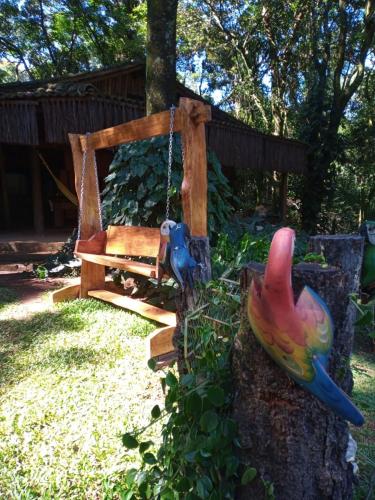 a swing and a bench in a yard at Chalé Cores da Mata in Brumadinho