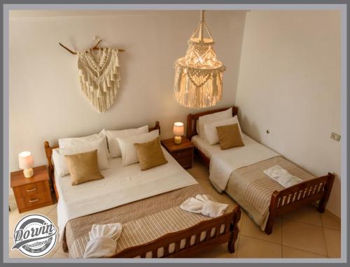 a bedroom with two beds and a chandelier at Dorvin Apartments in Dhërmi