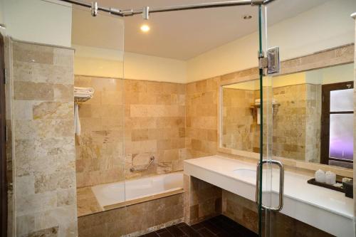 a bathroom with a tub and a sink and a shower at Kamala Beachfront Apartment in Kamala Beach