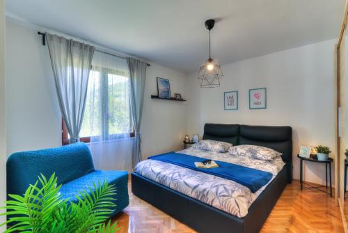 a bedroom with a bed and a blue chair at Holiday house KIM in Kali